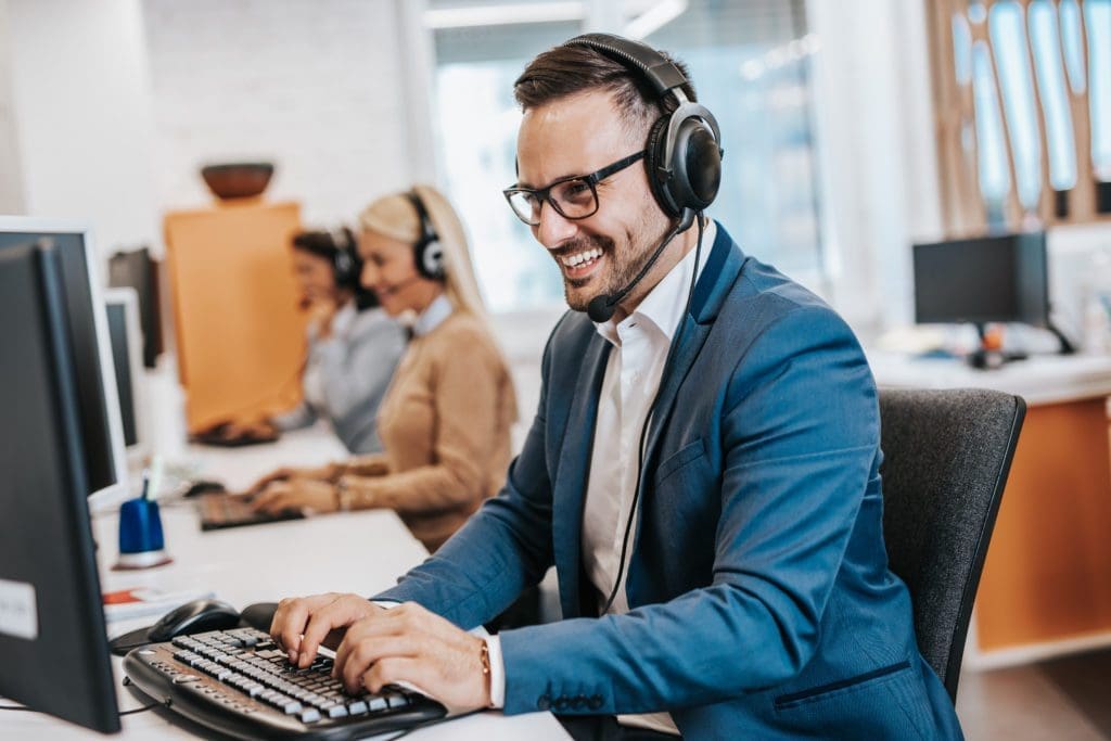Handsome male customer service agent working in call center offi