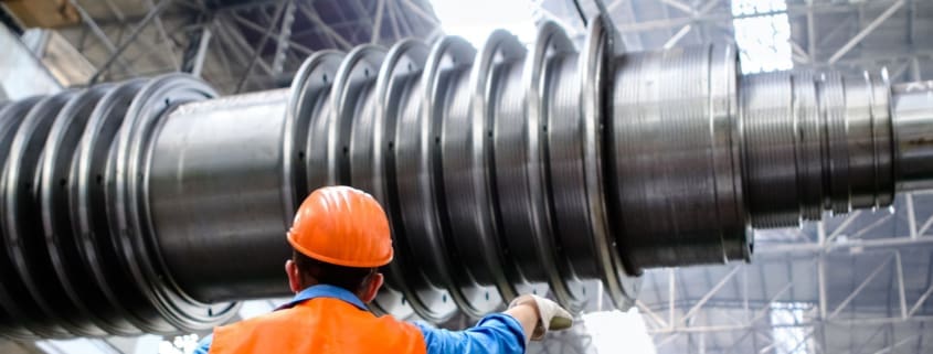 Technician inspecting a large industrial machine component