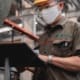 Technician inspecting industrial equipment with a tablet